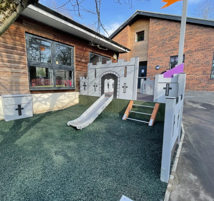 Installed castle-themed play area with a slide and climbing steps