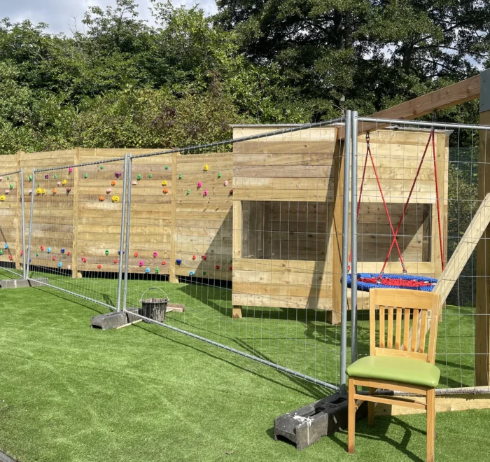 Timber climbing wall, shelter and basket swing during installation at Starlings