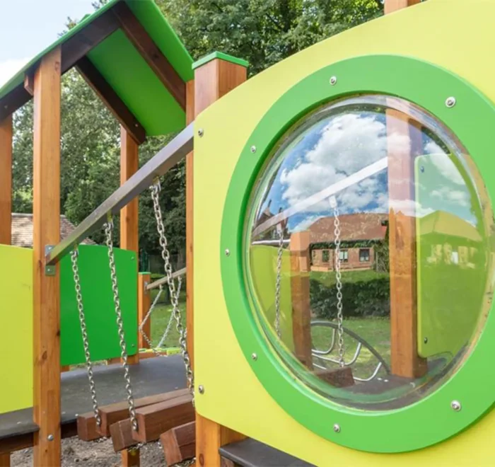 Close-up of a circular bubble window on a colourful timber play structure