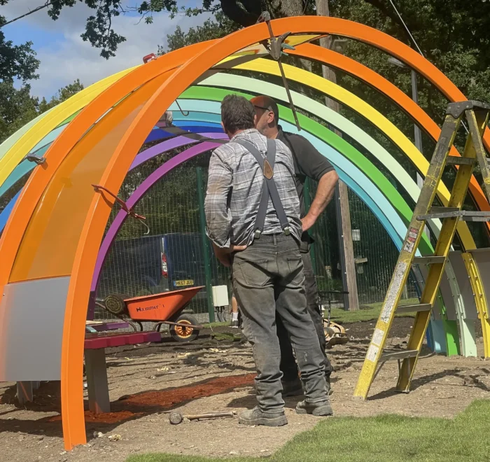 Installation of the rainbow playground shelter and its coloured panels